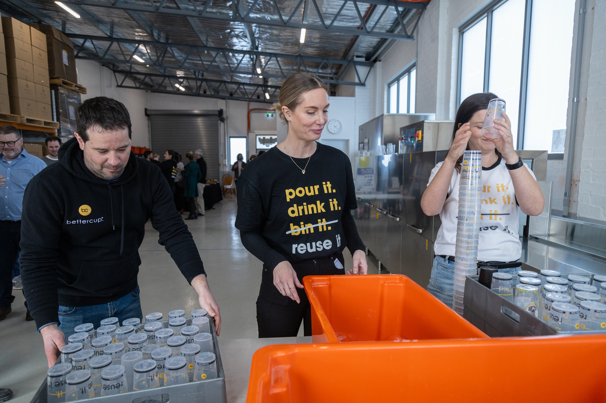 Staff sorting and organising used cups for industrial washing process