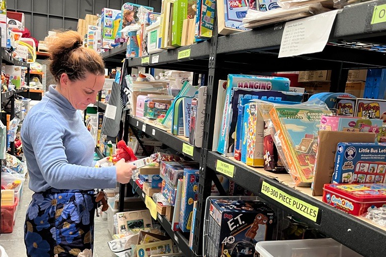 woman standing among shelves of toys